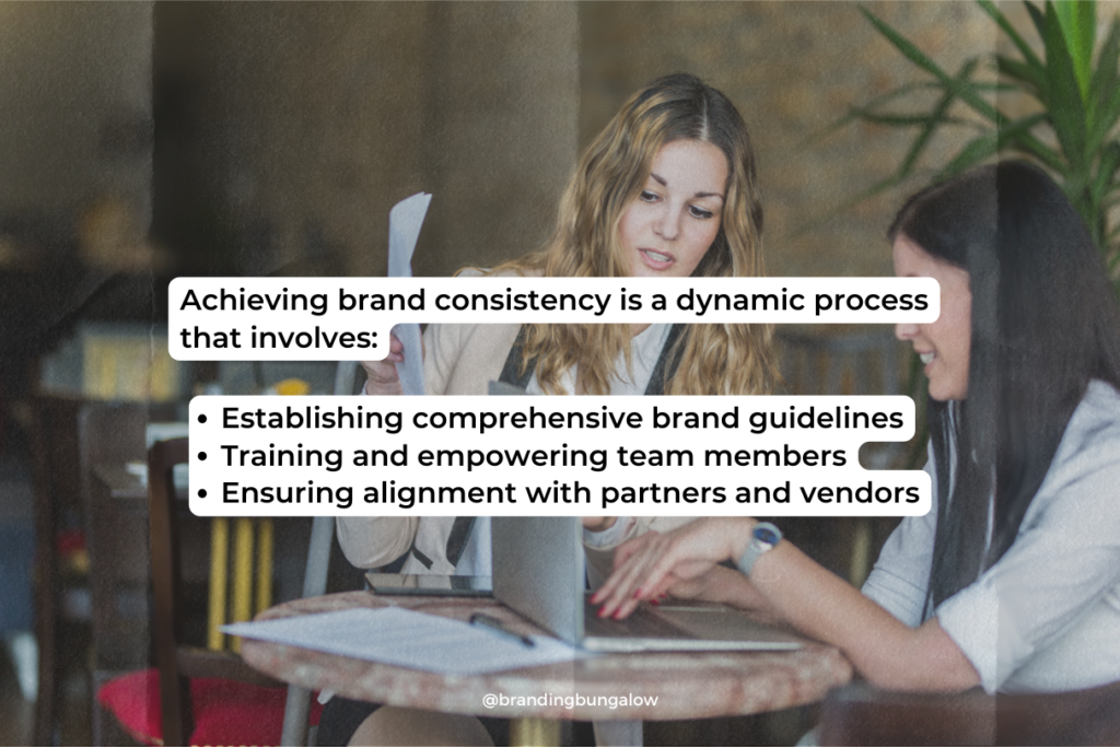 A manager helps train a new designer in branding consistency.